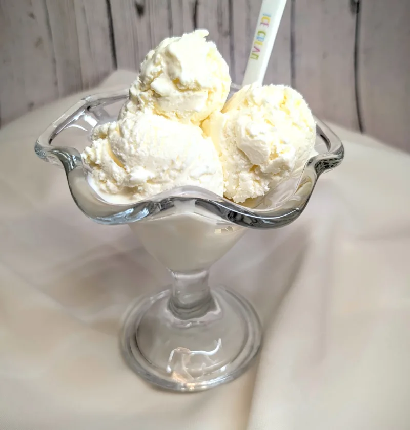 Zuckerfreier Frozen Yogurt in einem Eisbecher mit mehreren Kugeln, serviert auf weißem Tuch – cleanes, selbstgemachtes Low-Carb-Joghurteis für den Sommer.