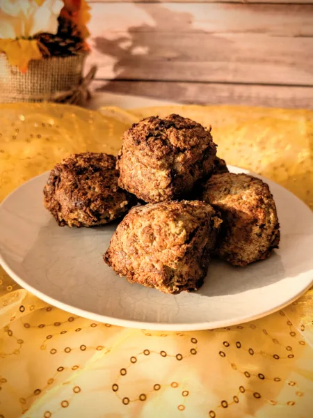 Saftige Hackbällchen aus gemischtem Hackfleisch auf einem weißen Teller, goldbraun gebraten und locker aufgeschichtet, fotografiert auf gelbem Stoff vor hellem Holz-Hintergrund.