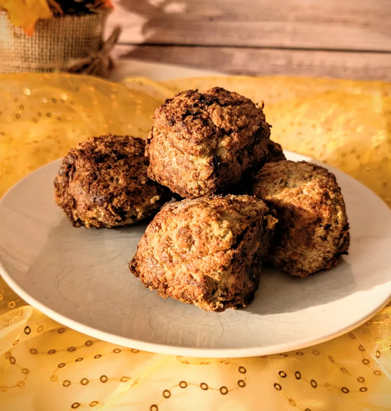 Saftige Hackbällchen aus gemischtem Hackfleisch auf einem weißen Teller, goldbraun gebraten und locker aufgeschichtet, fotografiert auf gelbem Stoff vor hellem Holz-Hintergrund.