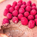 Cremige High-Protein Mousse au Chocolat in einer Glasschale, luftig aufgeschlagen aus Quark und Frischkäse und mit frischen Himbeeren dekoriert – ein eiweißreiches Frühstück zum Vorbereiten.